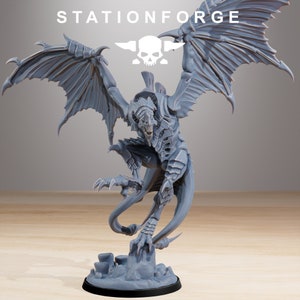 Op de afbeelding: Een grijze, gedetailleerde, 3D-geprinte miniatuur van een draak met wijd uitgespreide vleugels. De draak heeft een lange, dunne staart en scherpe klauwen. De miniatuur is in een dynamische aanvalshouding geposeerd.