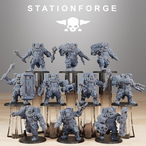 Op de afbeelding: Een set van tien grijze plastic miniatuurfiguren, elk met een andere pose en wapen, staand op een grijze en zilveren displaystandaard. De figuren dragen allemaal een harnas en dragen wapens, en ze kijken allemaal in verschillende richtingen. De figuren zijn allemaal ongeveer 5 cm hoog.