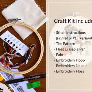 Shows the supplies included in this Halloween craft kit, including a bamboo embroidery hoop, a set of labeled DMC embroidery floss, cream colored cotton fabric, a heat erase pen used to transfer the pattern to fabric, an embroidery needle and the pattern with detailed instructions on how to complete the craft project.