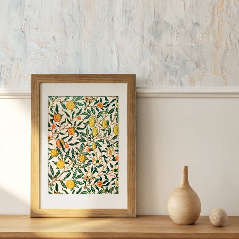 May include: A framed print of a vintage botanical illustration featuring a repeating pattern of green leaves, yellow lemons, and orange peaches on a cream background.
