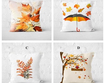 May include: Four different pillow designs featuring autumn themes. The first pillow has a watercolor painting of orange and yellow leaves. The second pillow has a black and orange umbrella with falling leaves. The third pillow has a brown and orange fern. The fourth pillow has a brown tree with an owl and a sign that says "Autumn".