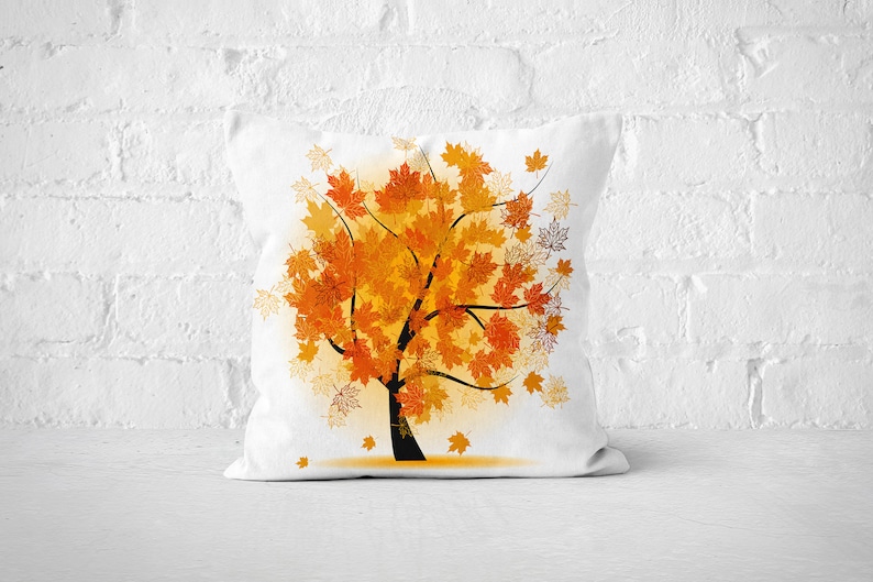 Pu&ograve; includere: Cuscino bianco con un design di albero autunnale colorato. L'albero &egrave; composto da foglie arancioni, gialle e rosse. Il cuscino &egrave; perfetto per aggiungere un tocco di arredamento autunnale alla tua casa.