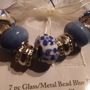 3 packs Trinkettes glass and metal bead sets, three matching strands in blue flowers, 7 pcs in each strand. Unopened. Made by Cousin.