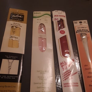May include: Four packages of zippers, each with a different color and brand. The first package is a Talon zipper in maize, 16 inches long. The second package is a Talon zipper in pink, 16 inches long. The third package is a red zipper, 16 inches long, made of polyester. The fourth package is a Clark's zipper, 16 inches long, with a white zipper.