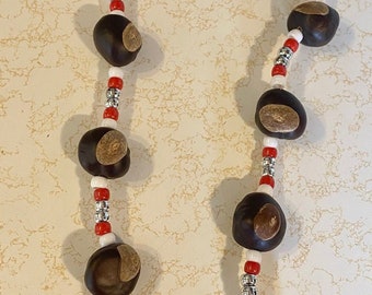 May include: A necklace made of brown buckeyes with red and white beads.