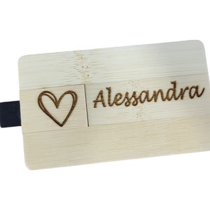 Può includere: Un'unità USB in legno con un cuore e il nome "Alessandra" inciso.
