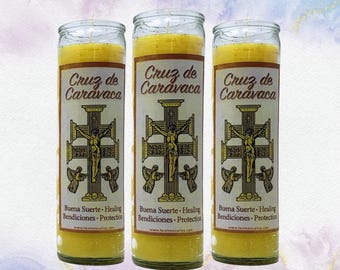 Puede incluir: Tres velas de vidrio amarillo con el texto "Cruz de Caravaca" y una imagen de una cruz con una figura. Las velas también tienen el texto "Buena Suerte Healing Bendiciones Protection".
