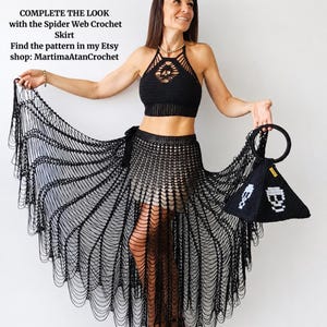 K&ouml;nnte beinhalten: Ein schwarzes H&auml;kel-Neckholder-Top und ein passender schwarzer H&auml;kelrock mit Spinnennetz-Muster. Der Text lautet: COMPLETE THE LOOK with the Spider Web Crochet Skirt. Find the pattern in my Etsy shop: MartimaAtanCrochet. Eine schwarze Pyramidentasche.