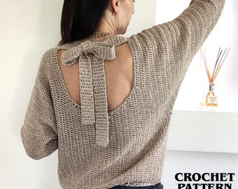 May include: A beige crochet sweater featuring long sleeves and a large open back design with a decorative bow tie closure at the top. The garment is crafted with a textured stitch pattern and includes the text CROCHET PATTERN INSTANT DOWNLOAD.