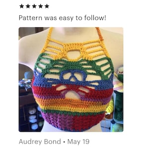 Puede incluir: Un top halter de ganchillo multicolor que presenta una vibrante paleta de colores arco&iacute;ris con hilo amarillo, verde, azul, rojo y morado. La prenda tiene un patr&oacute;n geom&eacute;trico calado en el pecho y una secci&oacute;n base de ganchillo s&oacute;lido.