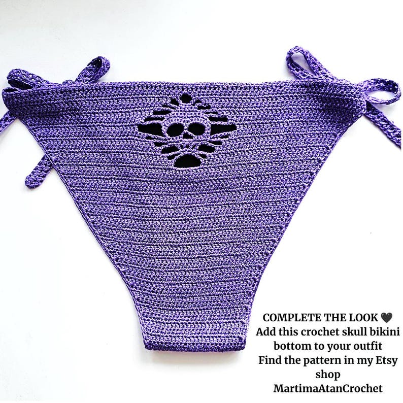 May include: A purple crochet bikini bottom featuring a cutout skull design in the center and side ties. The text on the image reads: COMPLETE THE LOOK. Add this crochet skull bikini bottom to your outfit. Find the pattern in my Etsy shop MartimaAtanCrochet.