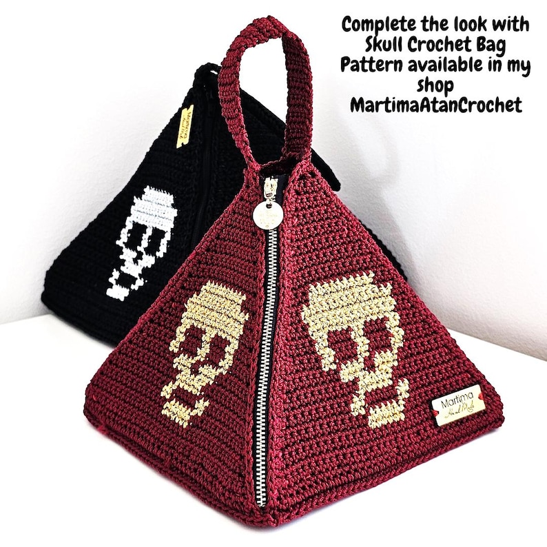 Puede incluir: Dos bolsos de ganchillo en forma de pir&aacute;mide, uno burdeos y otro negro, cada uno con un motivo de calavera. El bolso burdeos tiene una cremallera plateada, una etiqueta met&aacute;lica redonda y una etiqueta de marca rectangular. El texto dice: Complete the look with Skull Crochet Bag Pattern available in my shop MartimaAtanCrochet.