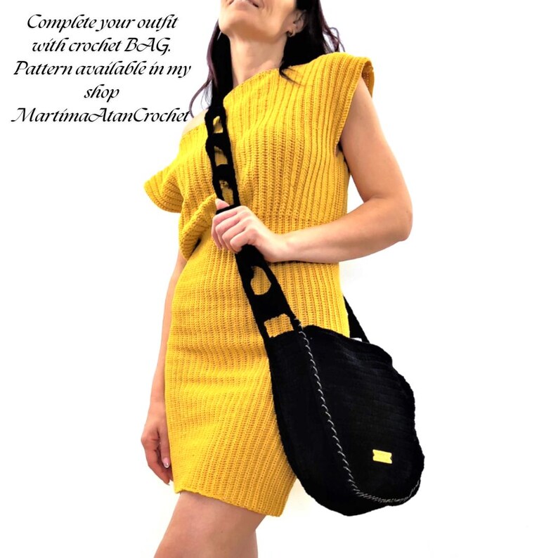K&ouml;nnte beinhalten: Eine Frau in einem gelben H&auml;kelkleid mit einer schwarzen H&auml;keltasche. Die Tasche hat einen langen Riemen, wei&szlig;e N&auml;hte und ein kleines gelbes Etikett. Der Text auf dem Bild lautet: Vervollst&auml;ndigen Sie Ihr Outfit mit einer H&auml;keltasche.