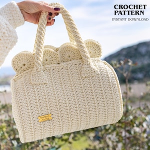 May include: Cream-colored crochet handbag with a scalloped top and braided handles. The bag features a rectangular shape and a small gold-colored tag. The text "CROCHET PATTERN INSTANT DOWNLOAD" is visible in the upper right corner.