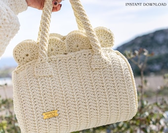 May include: A cream-colored crochet handbag featuring a textured vertical stitch pattern, two sturdy handles, and a scalloped top edge. A small rectangular gold-toned metal tag labeled Martima Hand Made is attached. Text reads CROCHET PATTERN INSTANT DOWNLOAD.