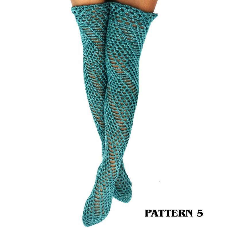 May include: A pair of teal thigh-high socks featuring an intricate openwork crochet pattern with a diagonal, swirling design. The socks extend from the upper thigh down to the feet, showcasing a consistent, textured knit structure throughout.