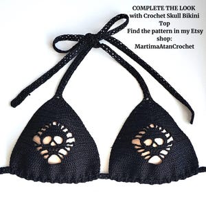 K&ouml;nnte beinhalten: Ein schwarzes H&auml;kel-Bikini-Oberteil mit einem Totenkopf-Motiv in jedem dreieckigen K&ouml;rbchen. Das Kleidungsst&uuml;ck hat d&uuml;nne Bindeb&auml;nder am Nacken und R&uuml;cken. Der Text auf dem Bild lautet: COMPLETE THE LOOK with Crochet Skull Bikini Top Find the pattern in my Etsy shop: MartimaAtanCrochet
