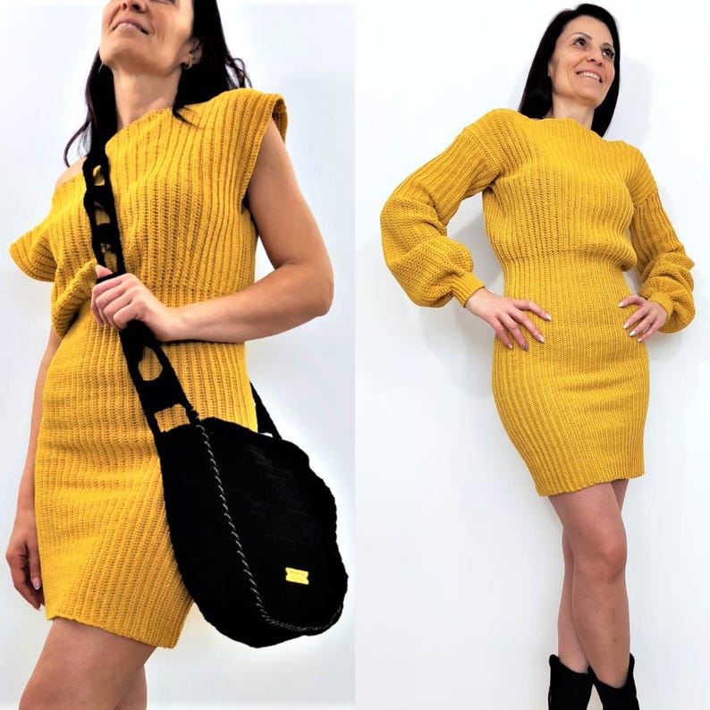 K&ouml;nnte beinhalten: Eine Frau tr&auml;gt ein senfgelbes Strickkleid und eine schwarze Umh&auml;ngetasche. Das Kleid hat eine gerippte Textur und eine figurbetonte Silhouette. Die Tasche ist gro&szlig; und rund mit einem dekorativen Riemen. Sie tr&auml;gt auch schwarze Stiefel.