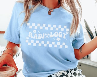 May include: A light blue t-shirt with a white checkered pattern and the text "RADIOLOGY" in a retro font with a radioactive symbol.