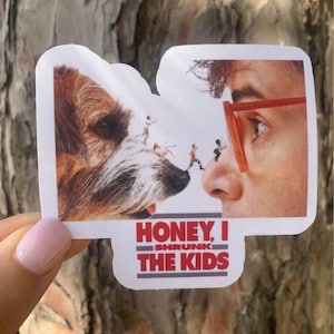 May include: A white sticker with a red and black graphic of a dog and a man's face. The text on the sticker reads "Honey, I Shrunk The Kids".