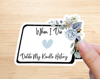 May include: A white sticker with black text that reads "When I Die Delete My Kindle History" with a blue heart in the middle. The sticker has a black border and a floral design with blue and green leaves.