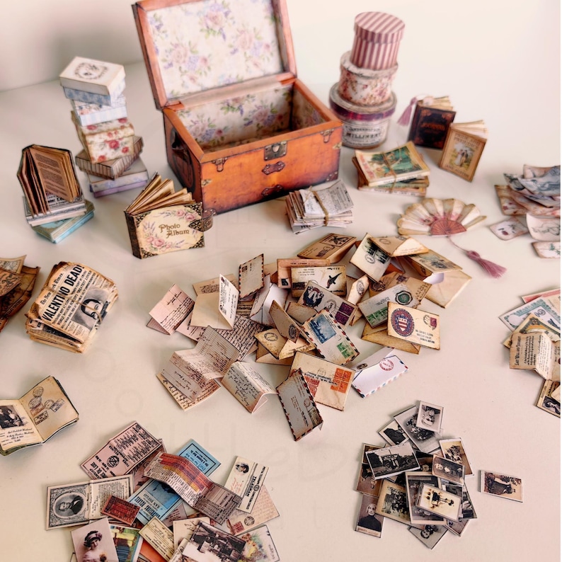 1:12 scale Victorian dollhouse miniature ephemera and accessory set. This printable digital kit features a vintage steamer trunk, floral photo album, personal journal, and over 200 nostalgic paper treasures. Designed by LittleBethMiniature for vintage dollhouse collectors.