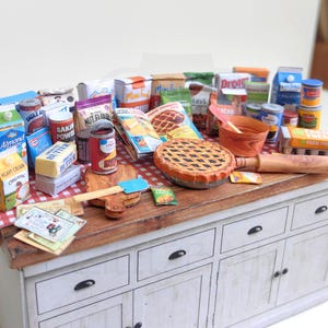 It is a Dollhouse Miniature Baking/ Cooking set that includes various items such as 45 different pieces Miniature Food, Mini Grocery boxes, Cooking Ingredients, Kitchenware, Recipes and Cookbook. Download PDF printables and get started making.
