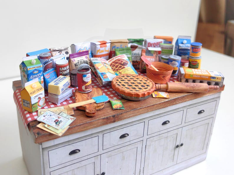 It is a Dollhouse Miniature Baking/ Cooking set that includes various items such as 45 different pieces Miniature Food, Mini Grocery boxes, Cooking Ingredients, Kitchenware, Recipes and Cookbook. Download PDF printables and get started making.
