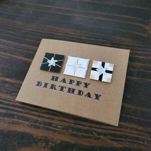 Tarjeta de cumpleaños hecha a mano "Cajas de regalo", papel marrón artesanal, estrellas acrílicas.