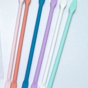 May include: Seven silicone stirring sticks in various colors: light blue, lavender, white, light green, pink, and two shades of coral.
