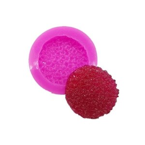 May include: Pink silicone mould with a textured surface, and a red candy with a similar textured surface.