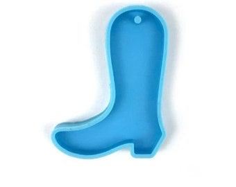 May include: A light blue silicone mold shaped like a cowboy boot. The mold has a hole at the top for hanging.