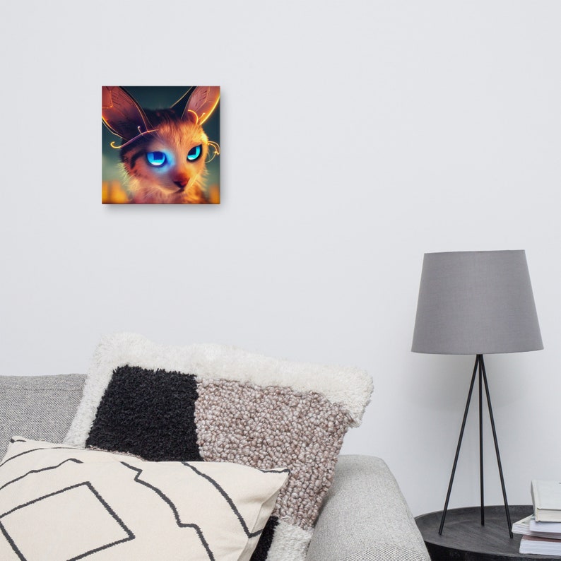 May include: Square canvas art featuring a stylized cat with large, glowing blue eyes. The cat has tan and brown fur with gold accents around the ears and eyes. The artwork is displayed on a white wall.