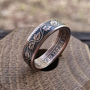 Op de afbeelding: Een zilveren ring gemaakt van een vintage munt met een ontwerp van bladeren en de inscriptie "D.G. VII DEI GRATIA".