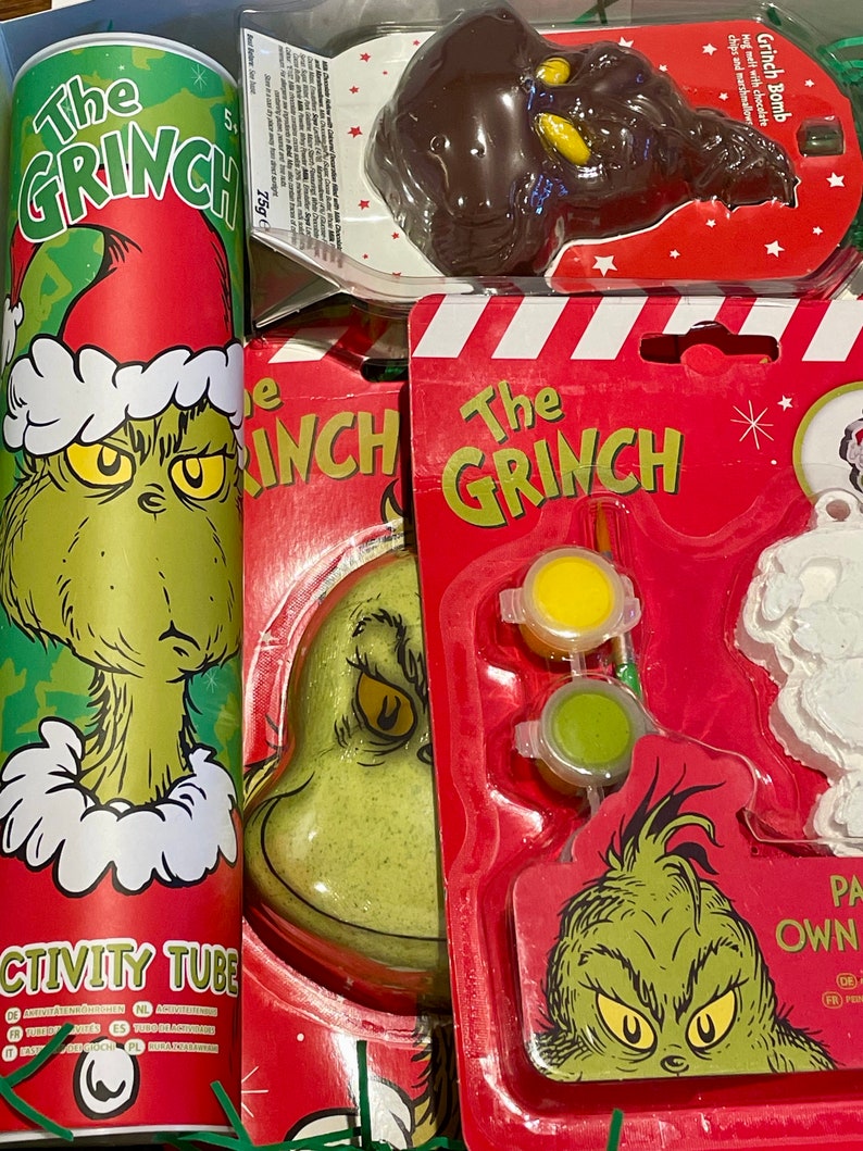 Puede incluir: Un set de regalo de Navidad con tem&aacute;tica de Grinch con una bomba de ba&ntilde;o verde Grinch, un tubo de actividades rojo y verde, una bomba de chocolate Grinch y un kit de adorno de Grinch para pintar con pintura amarilla, verde y blanca.