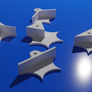 Può includere: Cinque angoli di plastica bianca con un foro al centro di ciascuno. Gli angoli sono su una superficie blu.