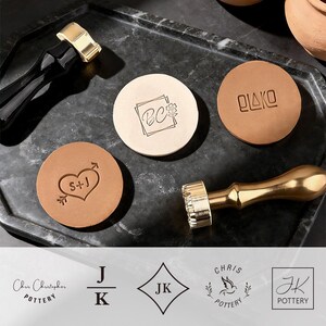 May include: A collection of personalized leather stamps and tools. The stamps feature initials, a heart with arrows, and other designs. The tools have black and gold handles. The image also includes logos for "Chris Christopher Pottery" and "JK Pottery".