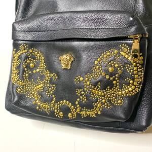 May include: A white ceramic mug with a black handle and the text "But First, Coffee" in a black, handwritten-style font. The mug is on a white surface.