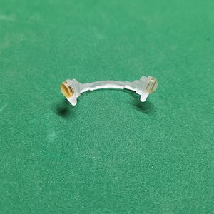 May include: A clear plastic nose bridge with gold-colored accents on each end.
