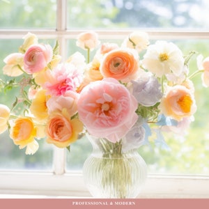 May include: A bouquet of pastel-colored flowers in a clear glass vase. The flowers include pink, yellow, peach, and white blooms. The vase is sitting on a windowsill with a view of a green, leafy background.