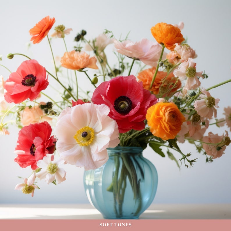 May include: A bouquet of pink, red, and orange flowers in a blue vase. The flowers are arranged in a loose, natural style. The vase is a simple, elegant design.