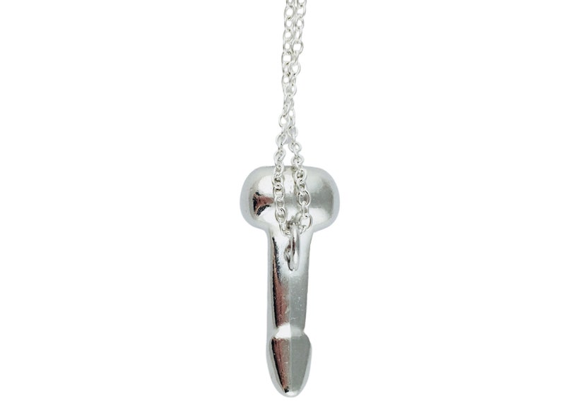 Pu&ograve; includere: Una collana con un ciondolo in argento con un design anatomico stilizzato. Il ciondolo &egrave; attaccato a una catena in argento.