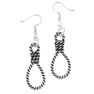 Puede incluir: Un par de pendientes plateados con diseño de soga corrediza. Los pendientes tienen apariencia de cuerda trenzada, con un lazo en la parte inferior y una sección anudada en la parte superior. Los ganchos son plateados, sobre fondo blanco.