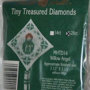 May include: A green package labeled "Tiny Treasured Diamonds" contains a cross-stitch kit. The kit features a design of a "Willow Angel" with an approximate finished size of 3.5 x 3.5 inches. The kit includes beads, fabric, floss, needles, and a chart.