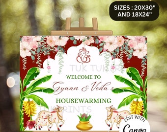 May include: A white sign with a red and floral border. The sign says "Welcome to Gyaan & Veda's Housewarming". The sign is on an easel and has a floral design with a Hindu deity at the top.