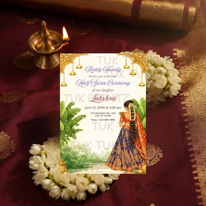 May include: An invitation card for a Half Saree Ceremony. The card features gold accents, a floral illustration, and the text "Reddy Family" and "Lakshmi". The card is set against a maroon background with flowers and a brass lamp.