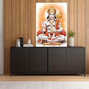 May include: A colourful print of the Hindu deity Hanuman, seated with a golden crown and mace. The artwork shows Hanuman in white and red garments, adorned with jewellery, against an orange backdrop. The print is displayed on a black cabinet.