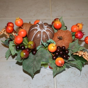 Thanksgiving Holiday Table Floral Arrangement in Fall Autumn Colors Berries Pumpkins Orange Red Brown Purple