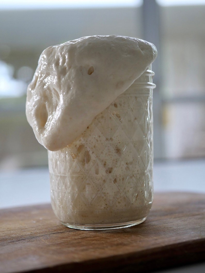 May include: A glass jar with a white, foamy substance rising above the rim. The jar has a textured, diamond-shaped pattern.