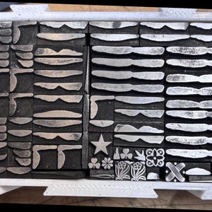 Printer's ornaments in a  2 x 3.5" interlocking biodegradable box.  Collection RF